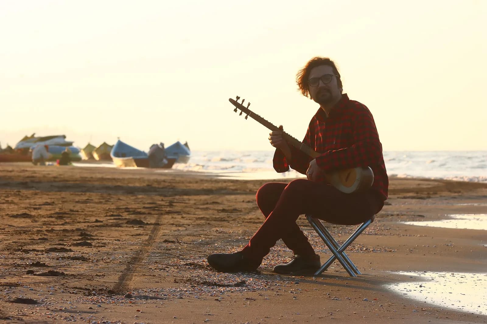 Iran: a setar player on the Caspian shore at sunset
